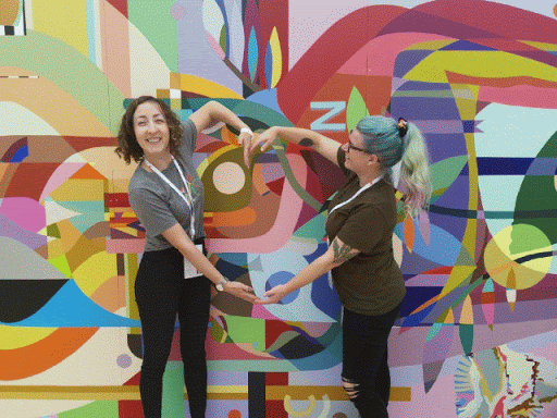 两个人在 Google I/O 大会上合影留念，相互手臂摆出心形图案